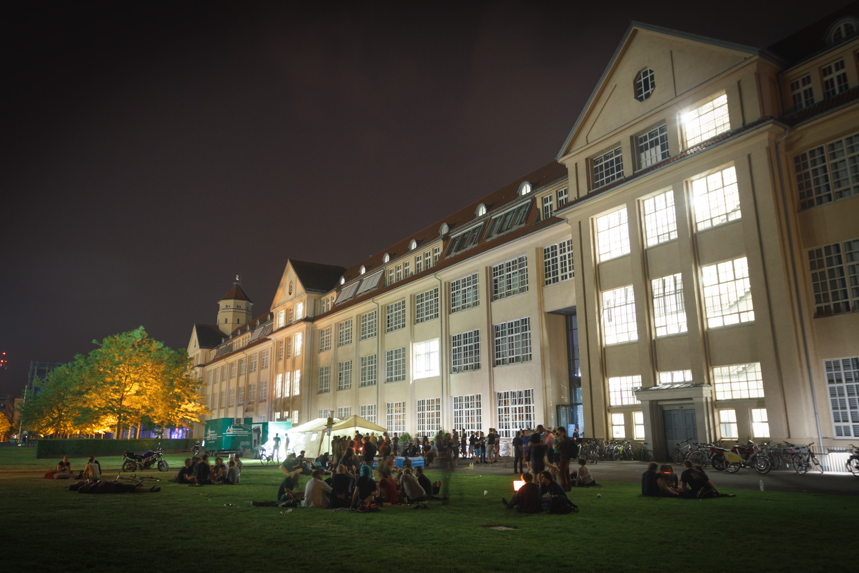 Hackers on grass behind ZKM at night.