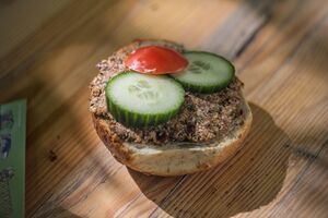 Brötchen bestrichen mit Leverwurst und belegt mit Gurkenscheibchen und einem Stück Tomate