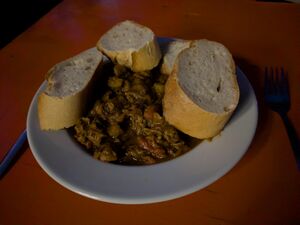 Ein Gulasch auf einem Teller, mit Brotscheiben